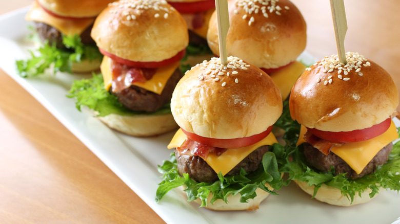 two rows of slider burgers on white tray
