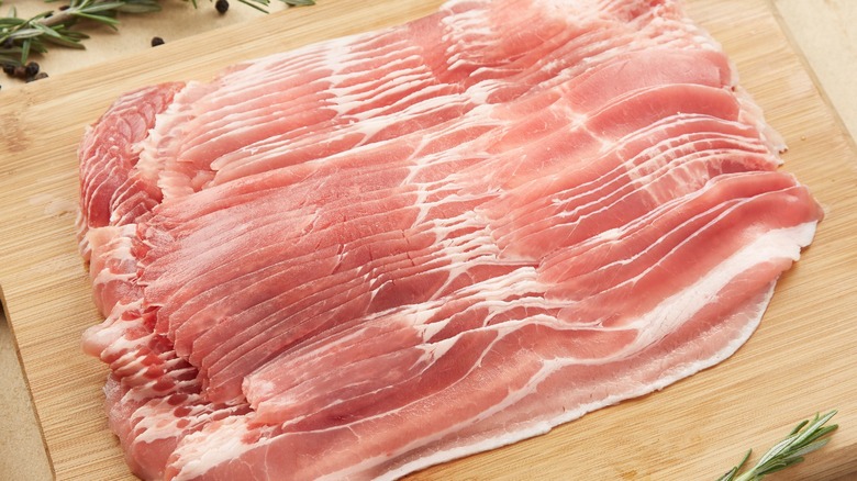 Raw bacon on a cutting board 