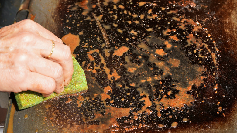 Cleaning a rusty flat top griddle with a sponge