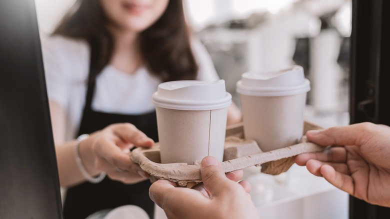 Worker serving two lattes to go