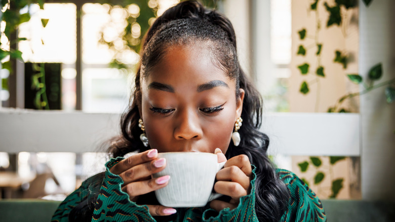 a woman enjoys a cup of coffee