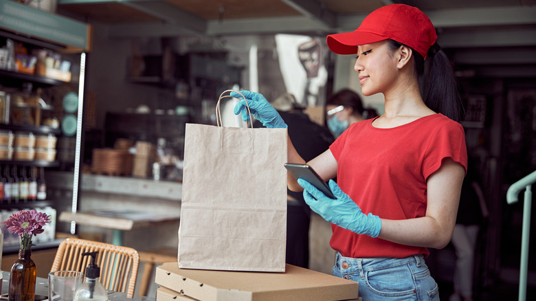 Fast food employee with a bag of food