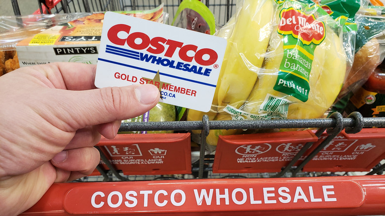Costco Wholesale member card in front of shopping cart full of food