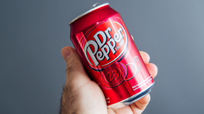 holding a can of Dr. Pepper