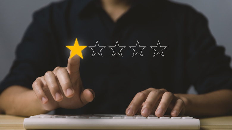 Concept of poor customer reviews, with a one-star rating lit up in front of a man on a keyboard