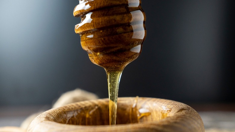 Honey drizzling from honey dipper
