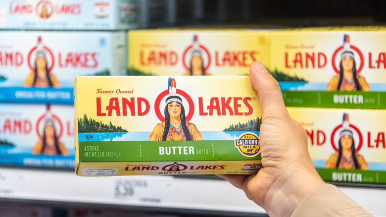 Hand holding a box of Land O Lakes butter