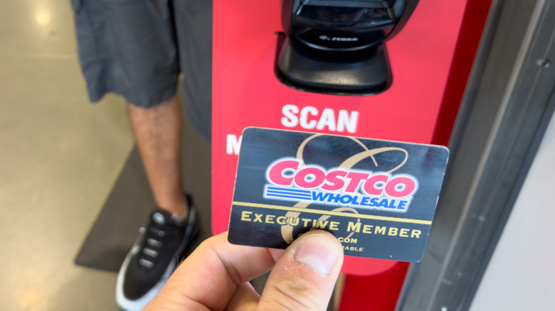 Costco customer holding an Executive Membership card to the scanner at the store entrance