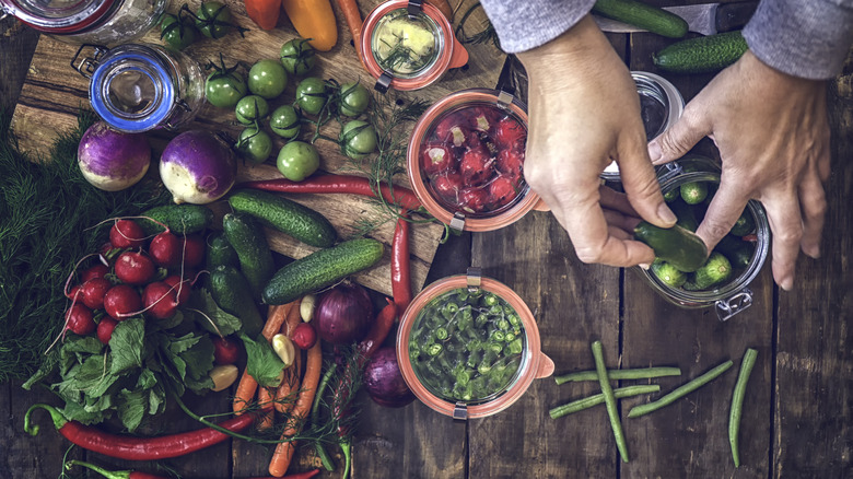 Hands pickling vegetables on wood board