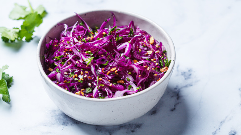 Purple coleslaw with cilantro and nuts in a bowl
