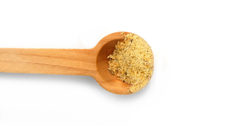 Ground spices in small wooden scoop