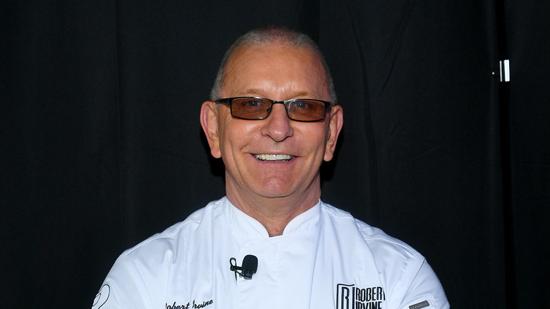 Chef Robert Irvine in front of black panel