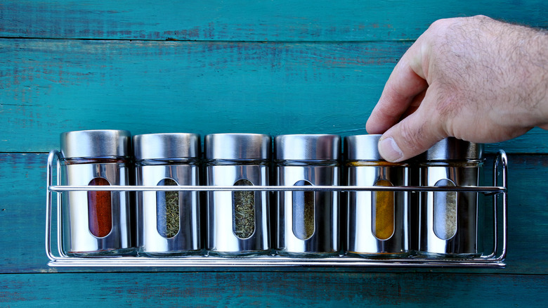 hand touching spice rack