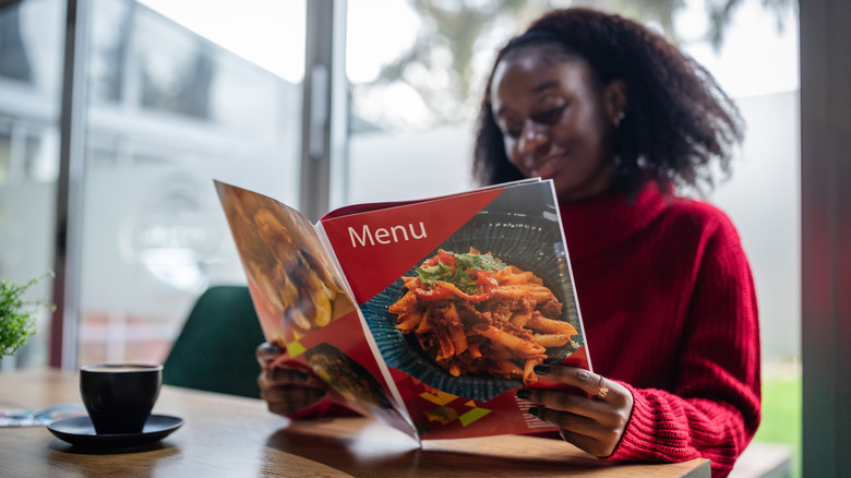 A woman perusing a dinner menu at a Chinese restaurant