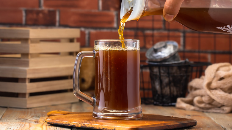 Root beer being poured from a pitcher to a glass