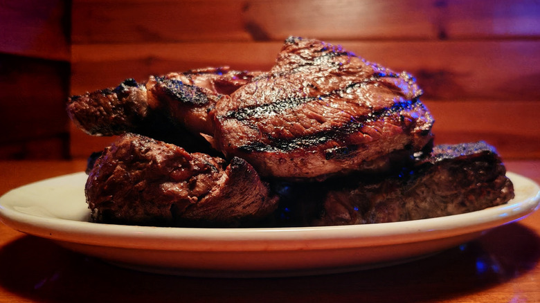 Plate of steaks stacked on top of each other on a booth table at Texas Roadhouse
