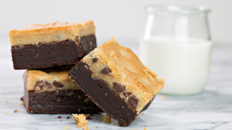 Brookies stacked next to a glass of milk