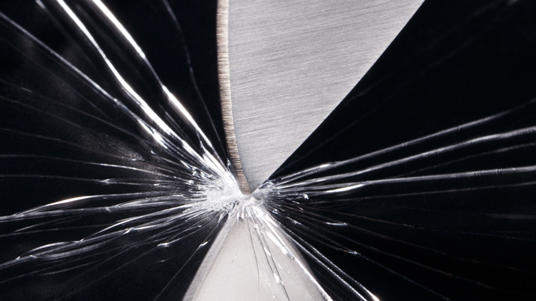 knife sticking into glass 