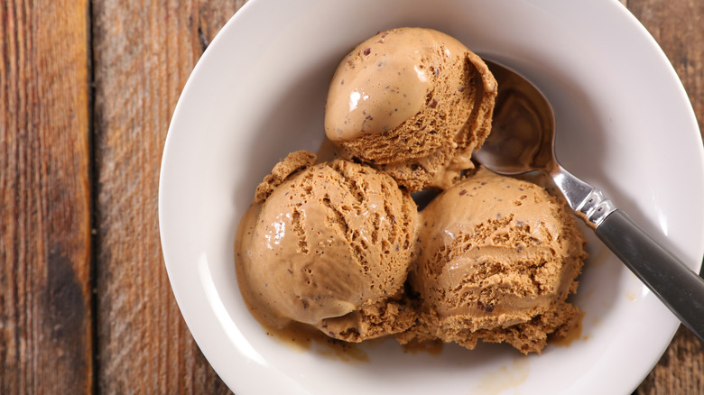 bowl of coffee ice cream with spoon on wooden table