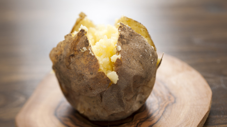 Plain baked potato on board