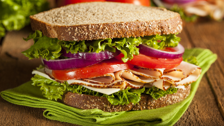 Sliced turkey sandwich with tomato and onion