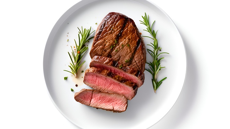 Sliced steak garnished with rosemary