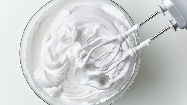 Hand mixer whipping a bowl of heavy cream