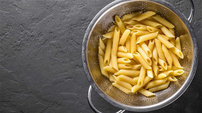 Penne pasta in silver colander