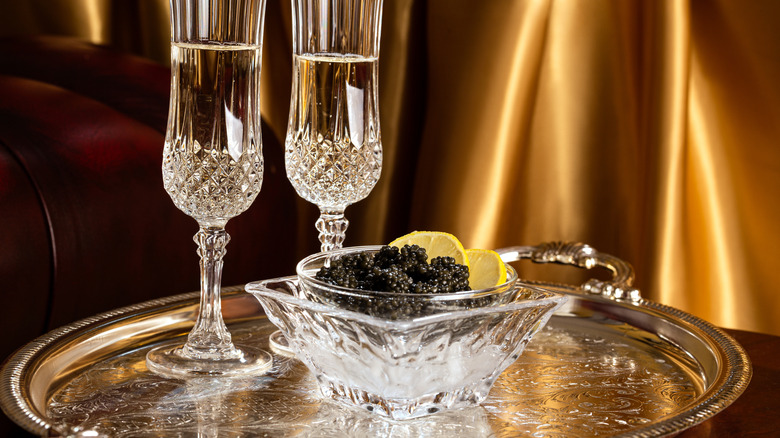 Crystal glasses with champagne and black caviar.
