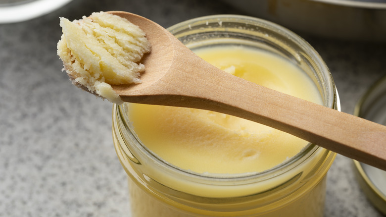 canned butter on wooden spoon