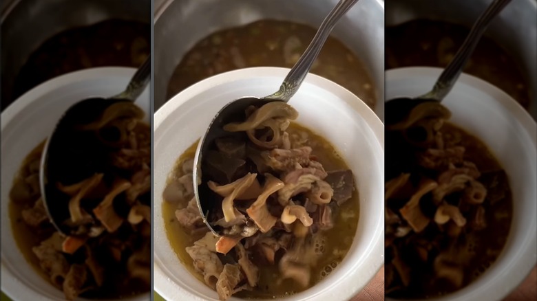 White bowl of papaitan with spoon