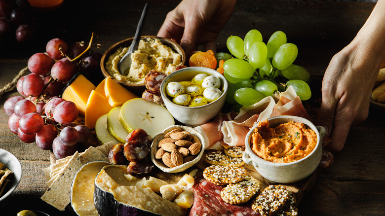hands setting down charcuterie board