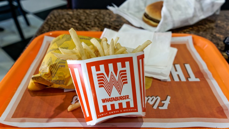 A tray with some Whataburger fries and a burger.