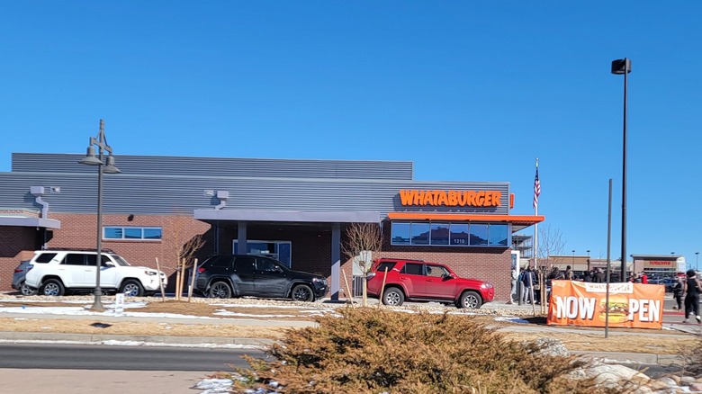 A Whataburger team in front of a Whataburger.