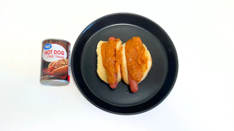Great Value hot dog chili sauce next to black plate with two hot dogs and sauce