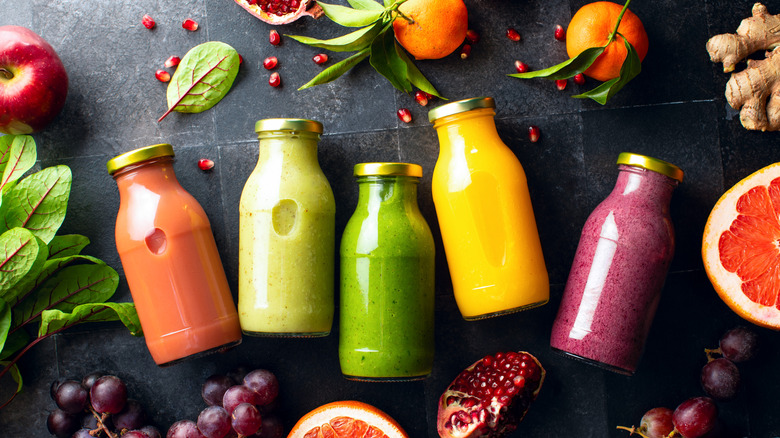 Various bottled smoothies on black surface