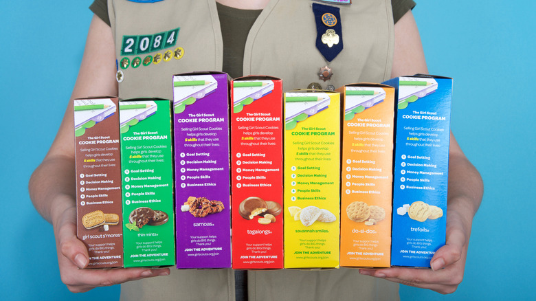Girl Scout holding cookie boxes