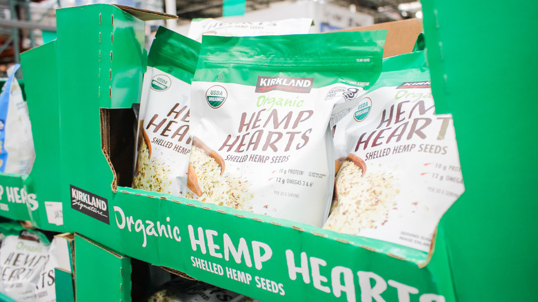 Three bags of Costco hemp hearts are visible in a box on a shelf in store