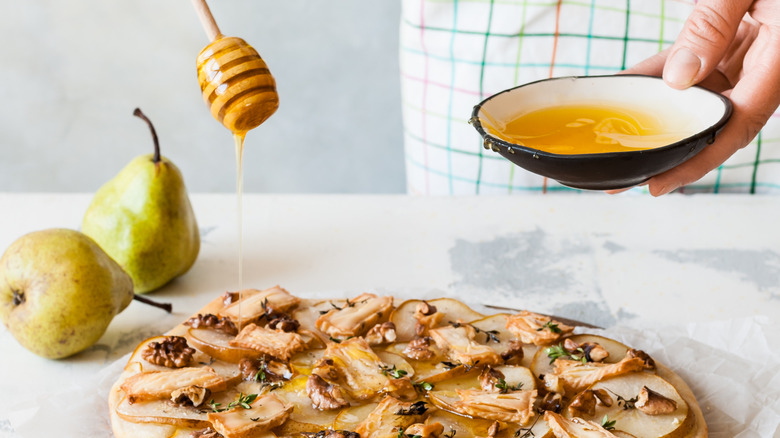 Drizzling honey over pizza