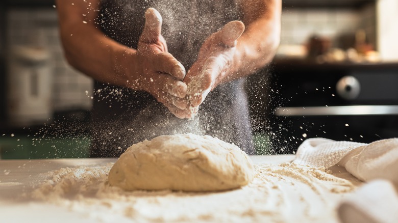 Hands making dough on table