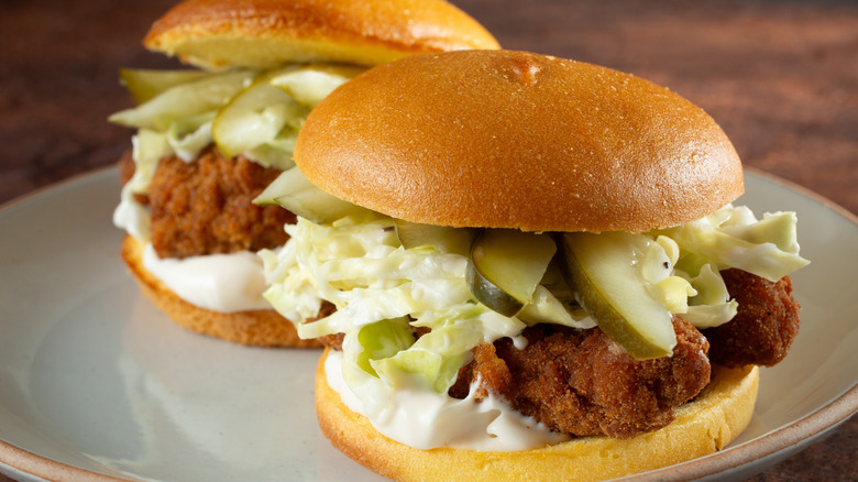 Two Nashville hot chicken sandwiches on a white plate