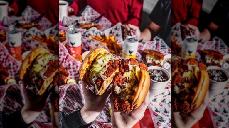 Hands hold two Howlin' Ray's sandos