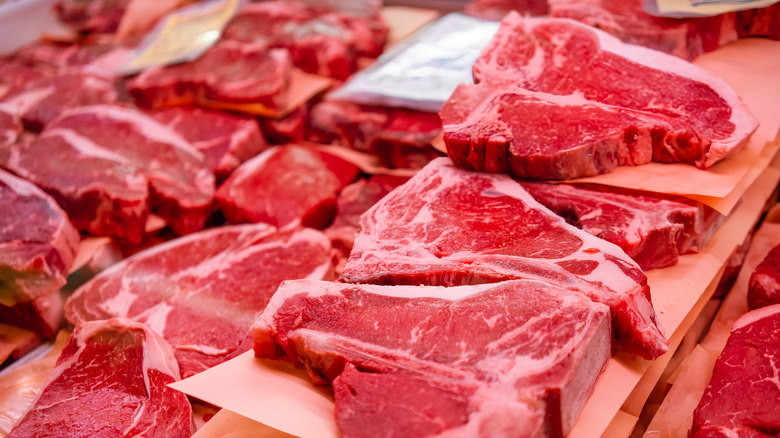 Various uncooked steaks on paper