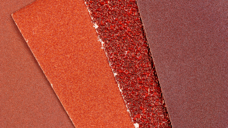 A person sharpening a knife on sandpaper