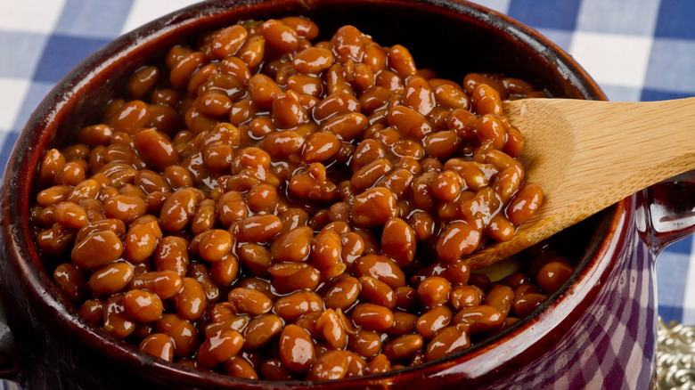 bowl full of baked beans with wooden spoon