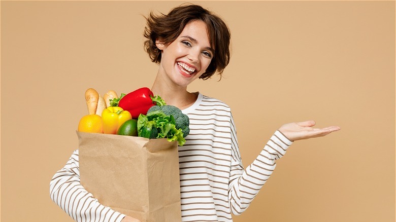 Woman smiling with bag of groceries 
