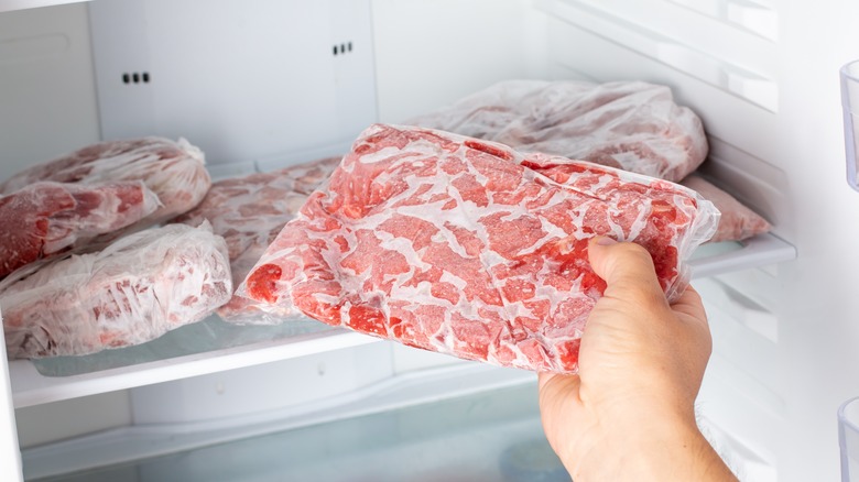 Removing frozen meat from freezer