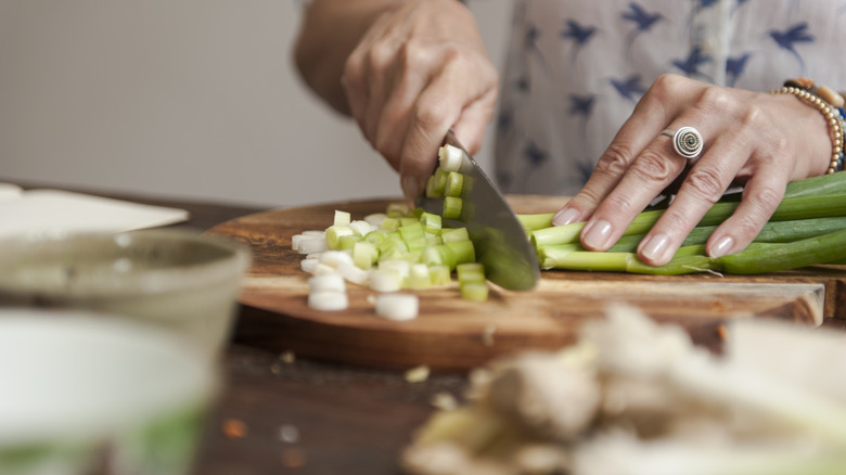 Person chopping green onions.