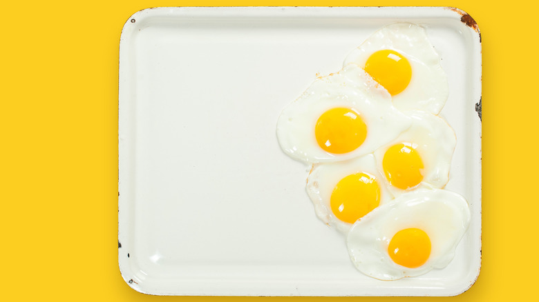 Five sunny-side up eggs on a sheet pan