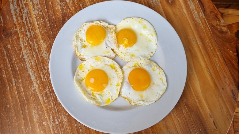 Four sunny-side up eggs on a plate